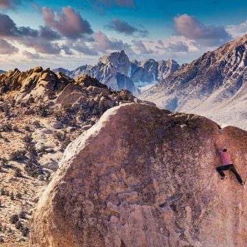 Man rock climbs on huge granite boulder in the Buttermilk area of Bishop, California with the Sierra Nevada behind Critique de ‘Accoster à la Vie’ par Gabriel Tallent