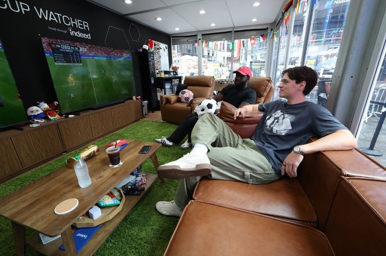Football fans watching all 104 World Cup matches in a glass box in Times Square Mondial 2026 : Les Résultats et les Enjeux