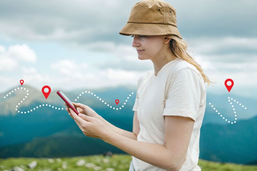 Success tourist woman searching right direction on smartphone on top of mountain with nature background. Mountain progression path. L’essor des applications de randonnée numériques