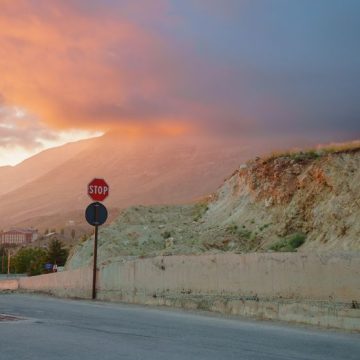 Serene sunset over mountain landscape with a stop sign and clouds Une maison au Levant : Exploration du Liban par Carole Dagher